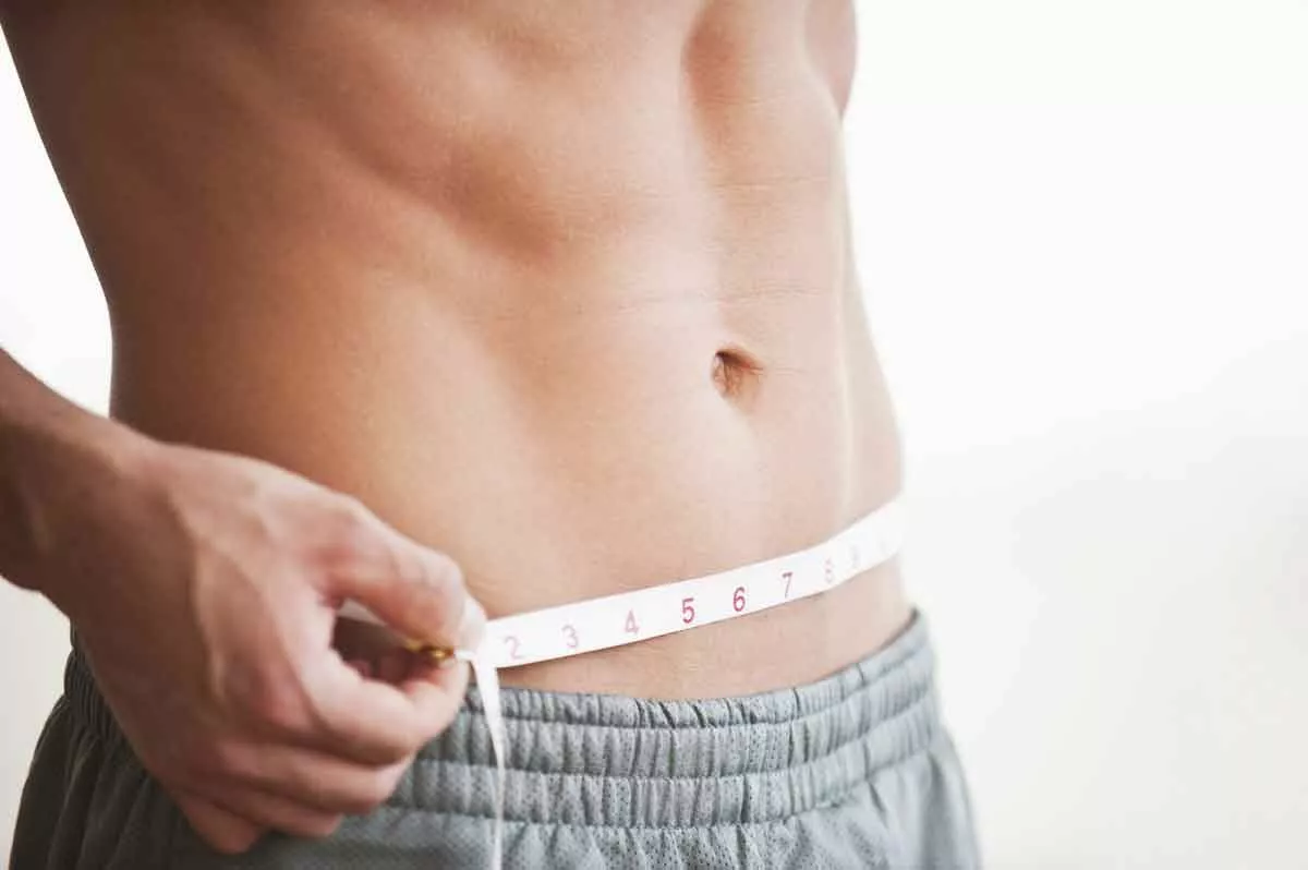 man measuring weight loss