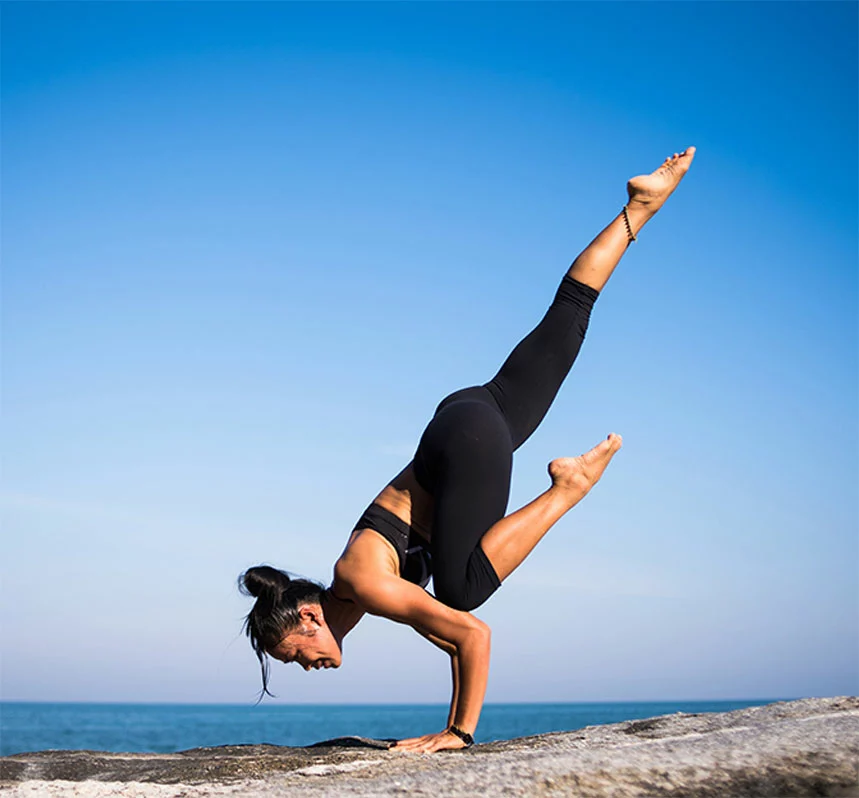 woman doing yoga pose on beach