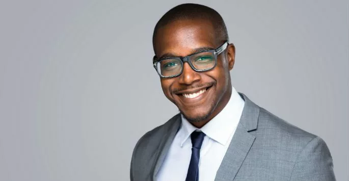 smiling man in a suit with glasses