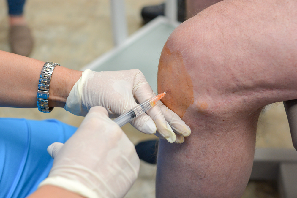 person receiving shot in knee as part of a regenerative medicine treatment