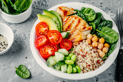 grilled chicken grain bowl with spinach, avocado, tomato, cucumber, edamame, and chickpeas